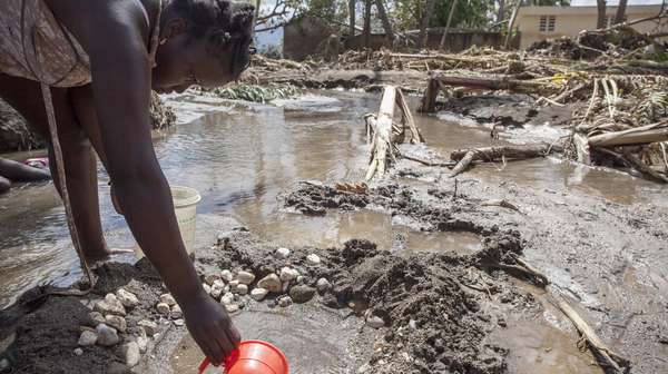 Eine Frau in Haiti schöpft nach Hurrikan Matthew verschmutztes Wasser