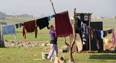 Eine Frau hängt Wäsche auf eine Leine.