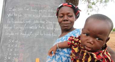 Mutter mit Baby bei Alphabetisierungskurs in Burkina Faso