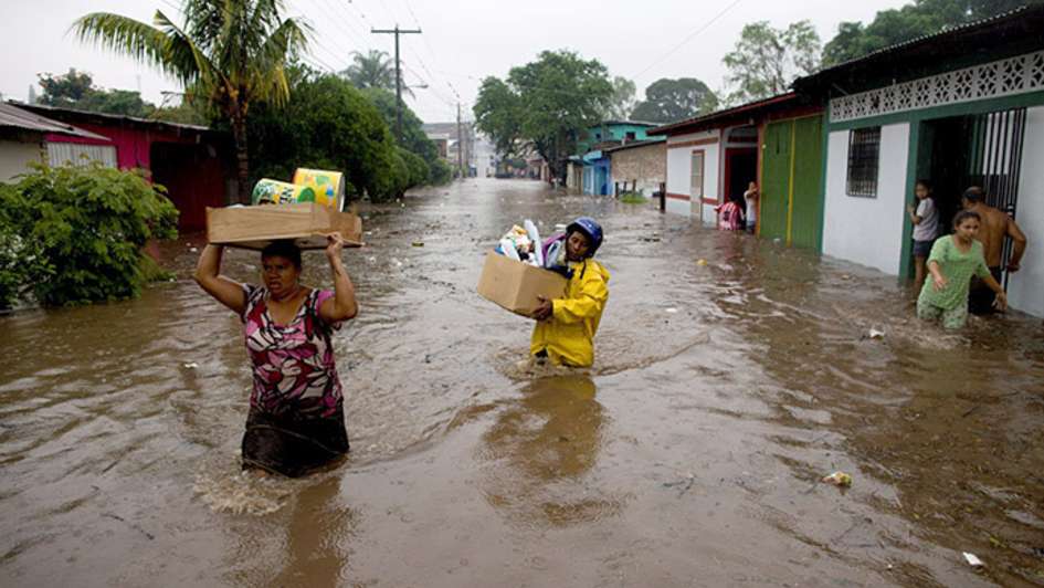 Flutopfer in Nicaragua transportieren ihr Hab und Gut durch Wassermassen.