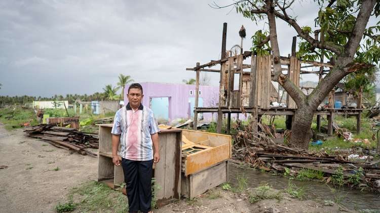 Ein Mann steht vor seinem zerstörten Haus.