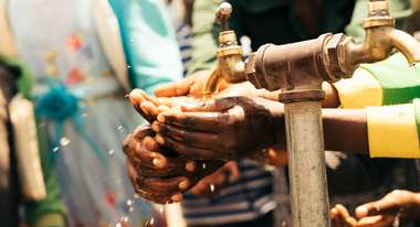 Ein Mädchen wäscht sich die Hände an einem Wasserhahn in Sodo, Äthiopien.