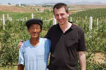 Dr. Wolfgang Jamann und Obstbauer Heun Hwang vor einem Feld