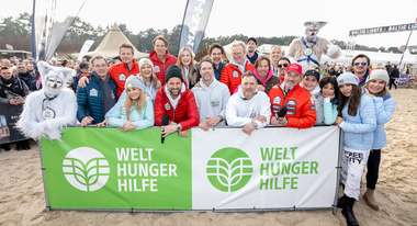Gruppenfoto prominenter Teilnehmer*innen am Baltic Lights 2024 vor einem Banner der Welthungerhilfe