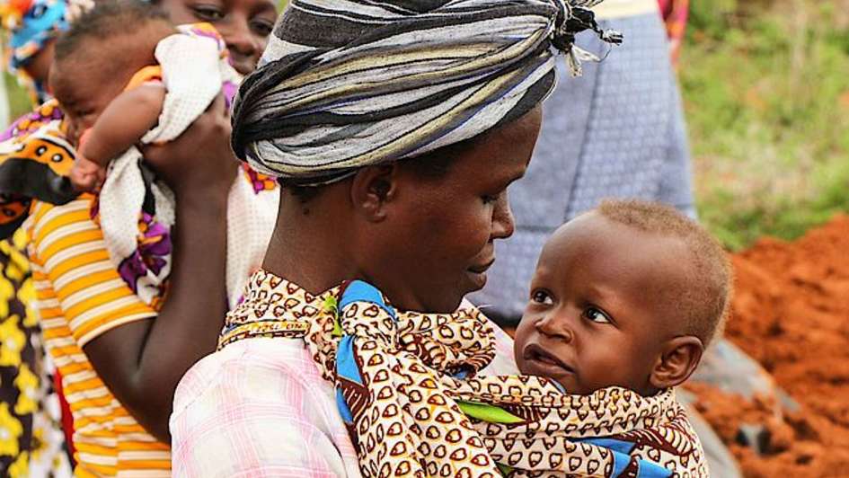 Eine Mutter hält ihr Kind fest im Arm.