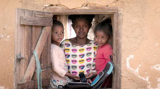 Eine alleinerziehende Mutter und ihre beiden Kinder schauen aus dem Fenster. Bargeldtransfers im Rahmen vorausschauender humanitärer Hilfe ermöglichen der Familie, auch in Krisenzeiten für sich sorgen zu können.