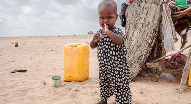 Ein Kleinkind steht während der extremen Dürreperiode, die 2017 Somaliland heimsuchte, vor einem Zelt in der Wüste.