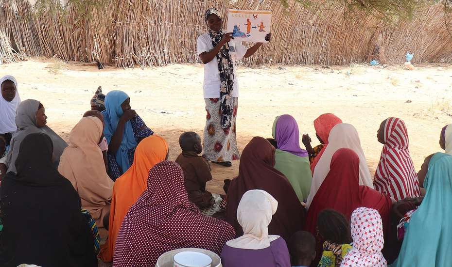 Eine Frau steht vor einer Gruppe Frauen unterrichtet sie, Niger 2021. 
