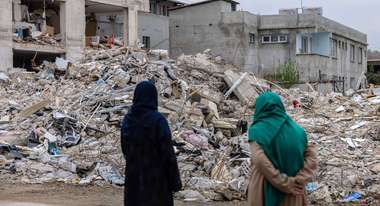 Nach dem Erdbeben in der Türkei: Zwei Frauen stehen vor den Trümmern eingestürzter Gebäude