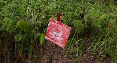 Ein rotes Schild mit einem Totenkopf darauf warnt vor Minen