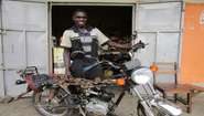 Ein Mechaniker im SkillUp!-Programm in Uganda repariert ein Motorrad.