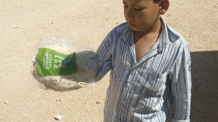 Refugee child with distributed bread in Camp Azaz, Syria. 