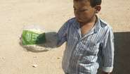 Refugee child with distributed bread in Camp Azaz, Syria. 