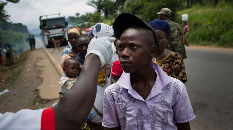 Passanten am Ebola- Checkpoint "Mile 4", die Koerpertemperatur wird gemessen.