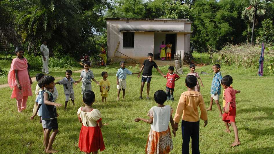 Children standing in a circle playing.