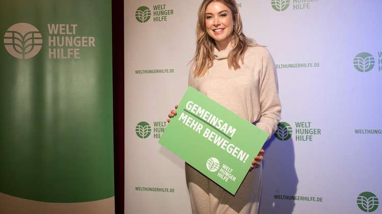 Nina Ensmann hält Schild der Welthungerhilfe in die Kamera
