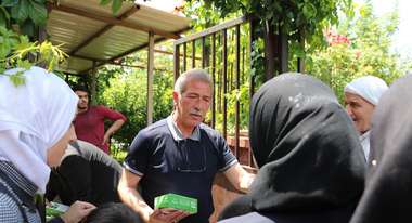 Ein Welthungerhilfe-Mitarbeiter verteilt Datteln an Flüchtlinge aus Syrien.