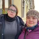 Zwei Frauen aus der Ukraine in warmer Kleidung stehen nebeneinander auf einem Gehweg, Polen 2022.