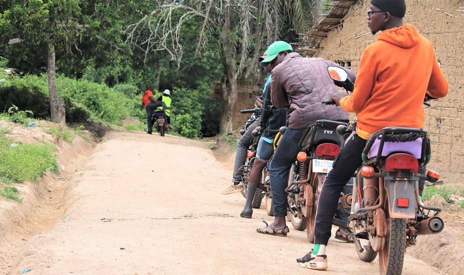 Männer auf Motorrädern halten am Rand einer Motorradpiste in Liberia