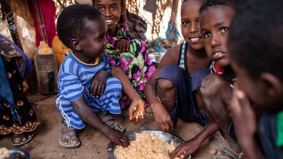 Kinder teilen sich Reis von einem Teller in Somaliland, 2018.