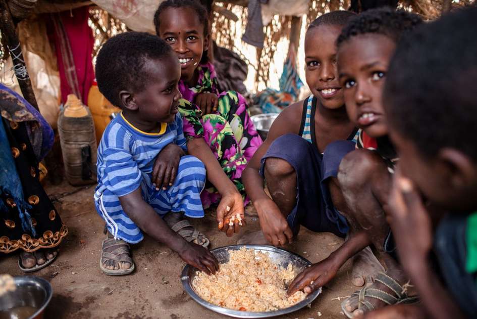 Kinder teilen sich Reis von einem Teller in Somaliland, 2018.