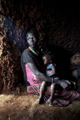 Frau mit schlafendem Kind in der Karamoja Region, Uganda, 2015.
