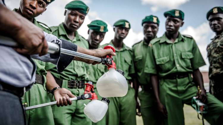 Ein Mann führt einer Armee Pestizidreiniger gegen Heuschrecken vor, Kenia.
