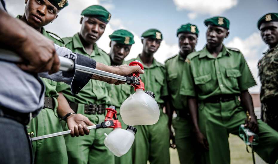 Ein Mann führt einer Armee Pestizidreiniger gegen Heuschrecken vor, Kenia.
