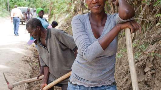 Haiti nach dem Erdbeben. Bild: Eine Frau mit einem Spaten.