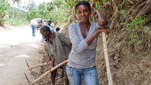 Haiti nach dem Erdbeben. Bild: Eine Frau mit einem Spaten.