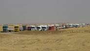 Hunderte Lastwagen stehen voll beladen neben den Feldern