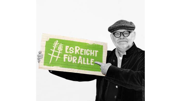 Regisseur und Schauspieler Jürgen Flimm hält ein Schild mit dem Welthungerhilfe-Hashtag #EsReichtFürAlle.