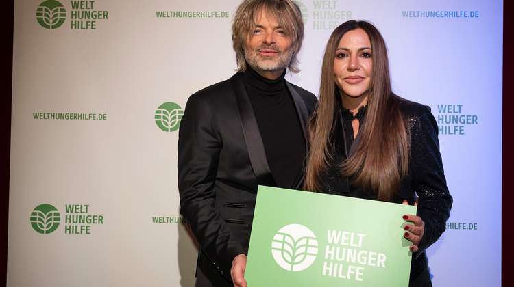 Nicolino Hermano und Simone Thomalla halten Schild der Welthungerhilfe in die Kamera