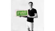Schauspieler Timothy Boldt hält ein Schild mit dem Welthungerhilfe-Hashtag #EsReichtFürAlle.