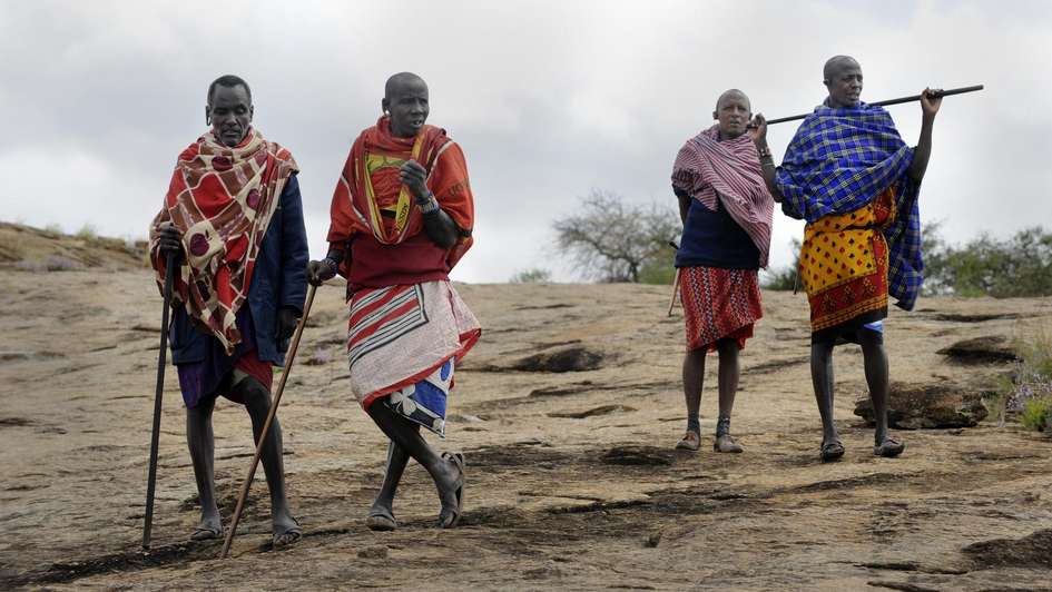 Massai aus Kenia stehen in einer kargen Landschaft