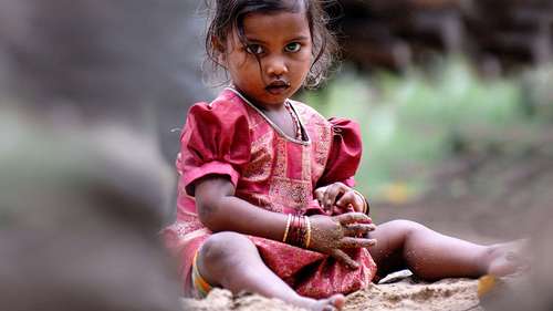 Ein Mädchen spielt auf dem Boden, Indien 2021.
