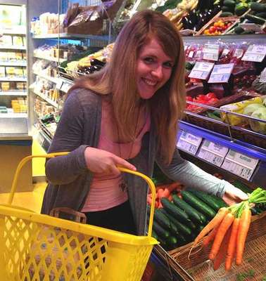 Janin kauft im Supermarkt ein und trägt dazu einen Einkaufskorb.