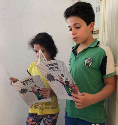 Zwei Kinder lesen in einem Comic, Türkei.