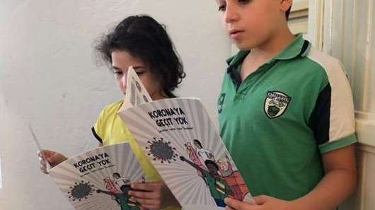Zwei Kinder lesen in einem Comic, Türkei.