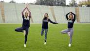 Karolin Kandle, Viola Weiss und Tina Kaiser machen Yoga-Posen.