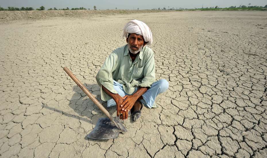 Ein Mann in Pakistan sitzt auf durch Dürre ausgetrocknetem Boden. Mit Frühwarnsystemen und vorausschauendem humanitären Handeln kann daraus resultierendes Leid gemindert werden.