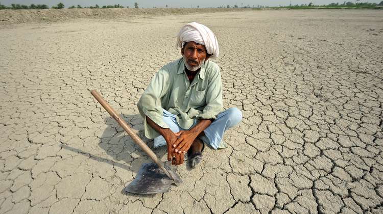 Ein Mann in Pakistan sitzt auf durch Dürre ausgetrocknetem Boden. Mit Frühwarnsystemen und vorausschauendem humanitären Handeln kann daraus resultierendes Leid gemindert werden.