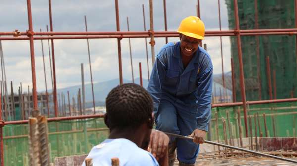 Zwei Männer im SkillUp!-Projekt sprechen auf einer Baustelle in Kenia miteinander.