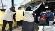 Mitarbeiter:innen der Welthungerhilfe tragen Schaumstoffmatratzen in eine Notunterkunft