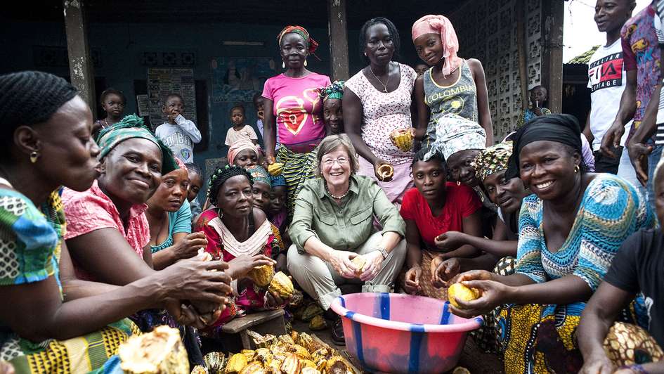 Welthungerhilfe-Präsidentin Marlehn Thieme beim Öffnen von Kakaofrüchten mit einer Frauengruppe in Sierra Leone