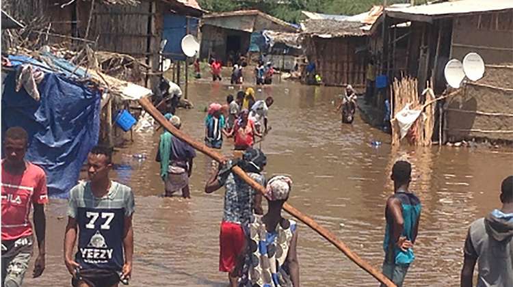 Menschen in überflutetem Dorf. Für Überschwemmungen in Afrika spenden.