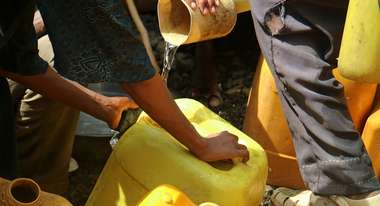 Menschen befüllen gelbe Kanister mit Wasser