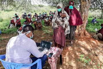 Corona-Hilfen: Menschen in Somalia registrieren sich für E-Gutscheine, mit denen Sie über ihr Handy bei ortsansässigen Händlern Saatgut oder Werkzeug kaufen können. 