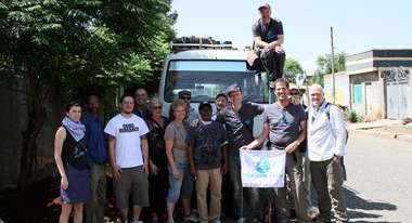 Mitarbeiter von der Welthungerhilfe und Viva con Aqua posieren vor einem Auto