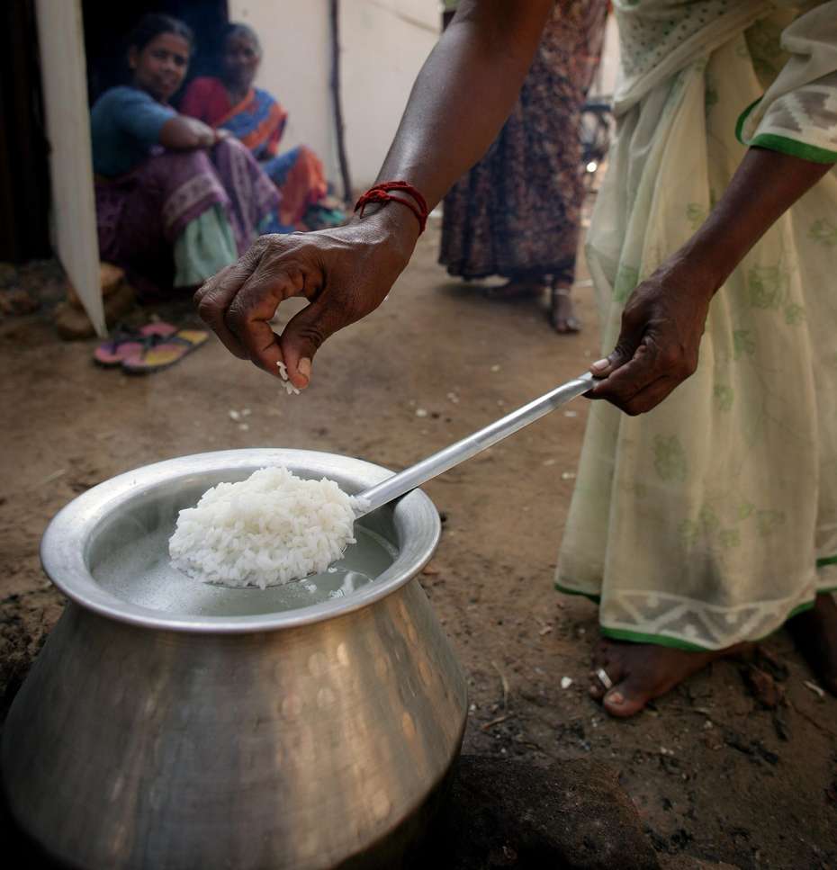 Ein Frau in Sengaratoppu, Indien kocht Reis.